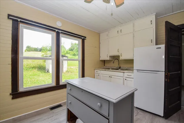 a kitchen with a stove a refrigerator and a cabinets