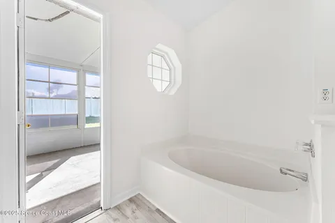 a white bath tub sitting next to a window