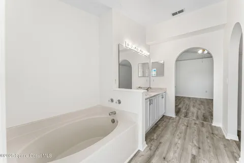 a bathroom with a bathtub a mirror a double vanity sink and vanity