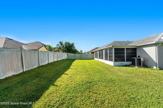 a view of a house with backyard and sitting area