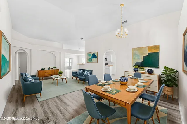a view of a dining room with furniture a rug and wooden floor
