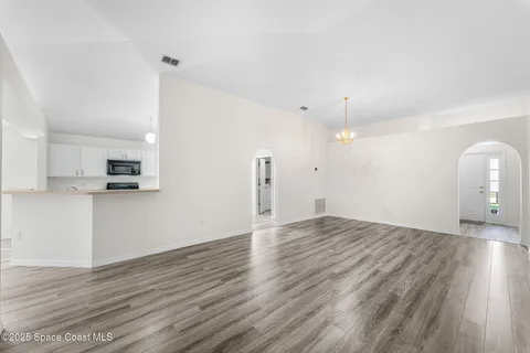 a view of a kitchen with wooden floor and a sink