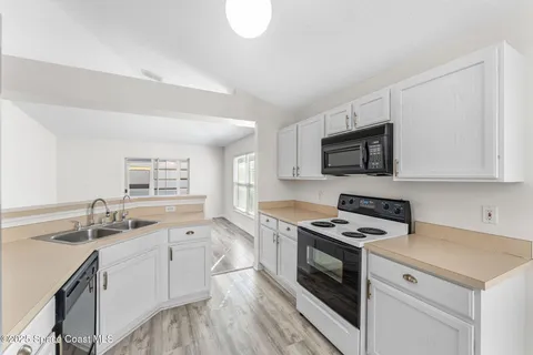 a kitchen with white cabinets stainless steel appliances and sink