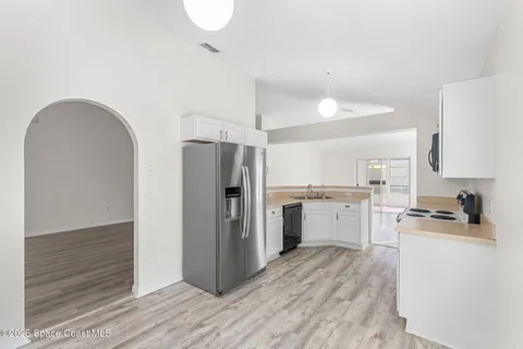 a kitchen with a refrigerator cabinets and wooden floor