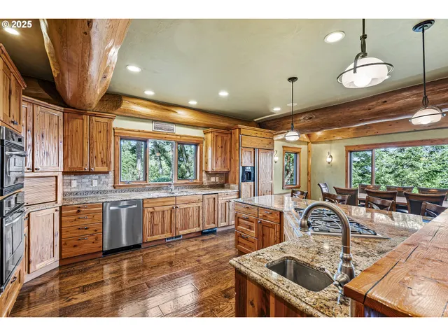 a kitchen with stainless steel appliances granite countertop a sink window and cabinets