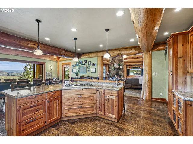 a kitchen with stainless steel appliances granite countertop a sink a stove and a wooden floors