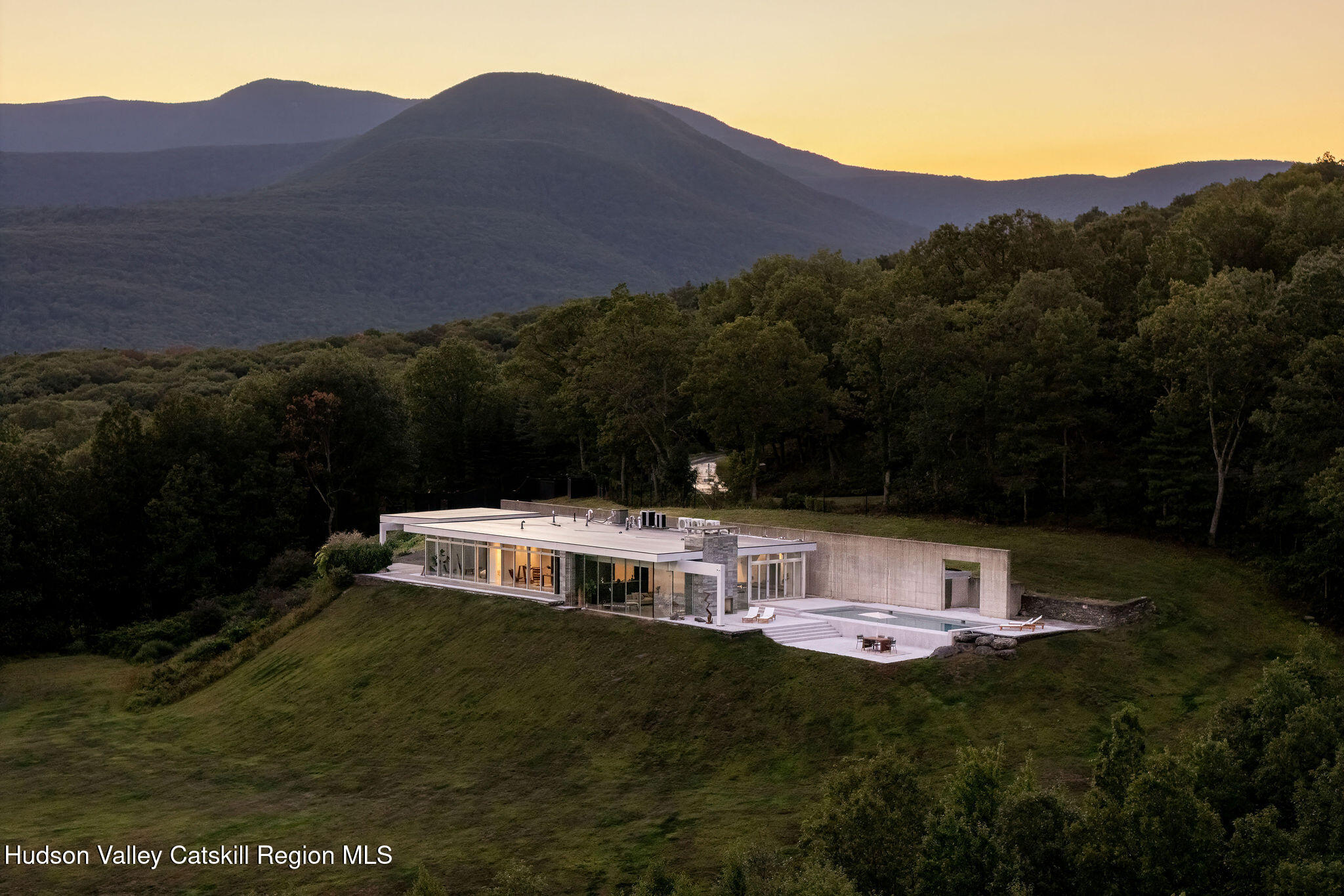 a view of a house with a yard and a forest