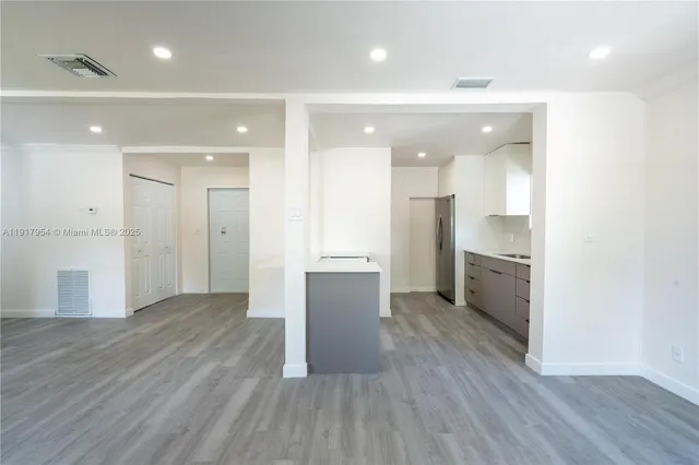 a view of a kitchen with a refrigerator and a sink