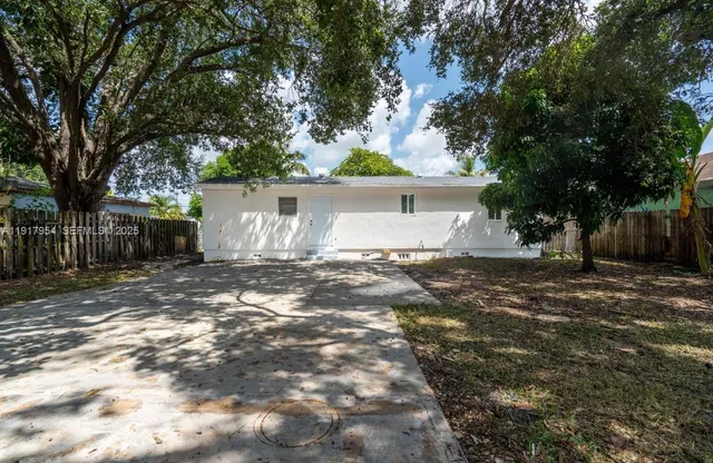 a view of a house with backyard and a tree