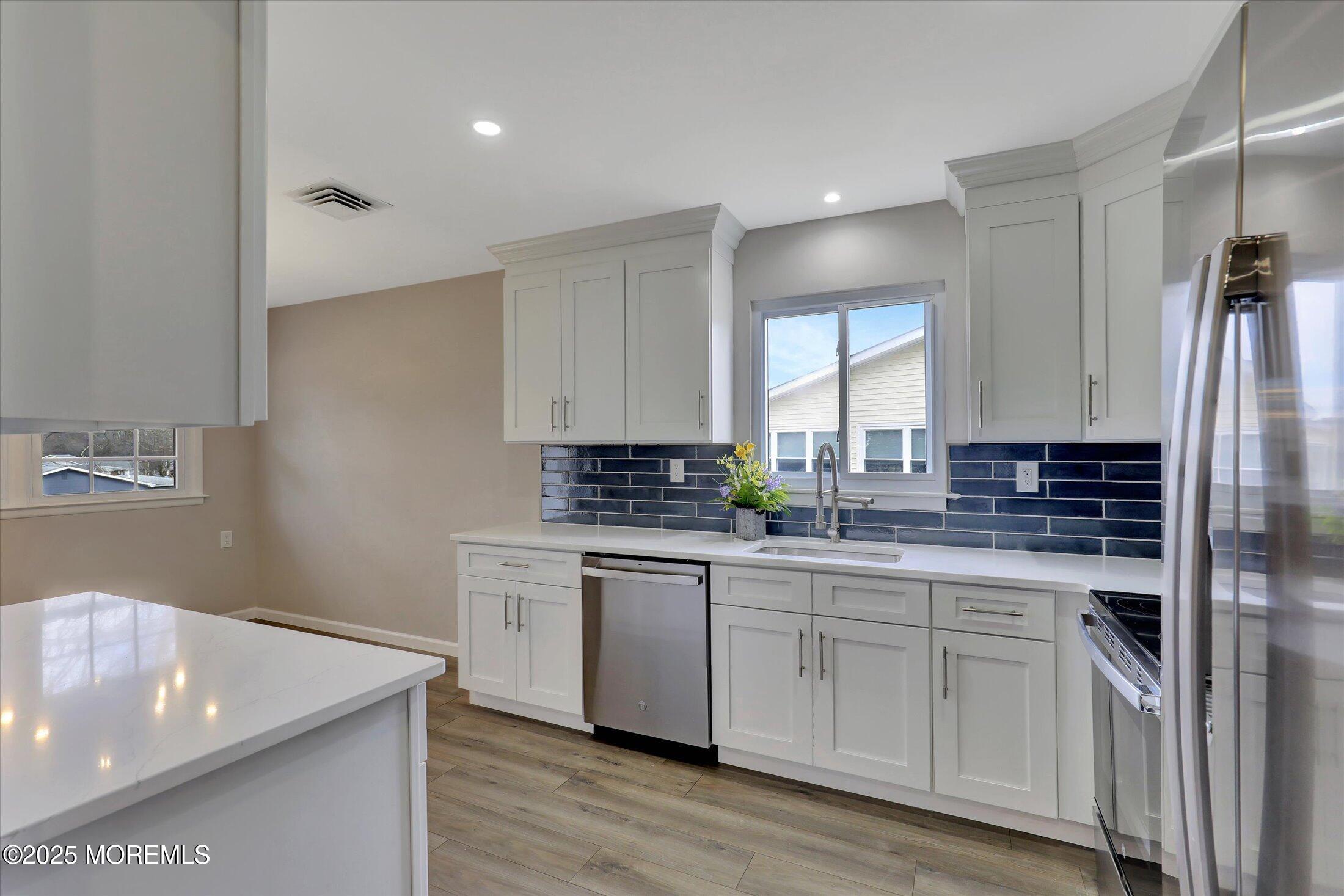 35 Patmore Road Brick, NJ 08724 - Photo 25 of 65 a kitchen with stainless steel appliances granite countertop a sink a stove and a refrigerator