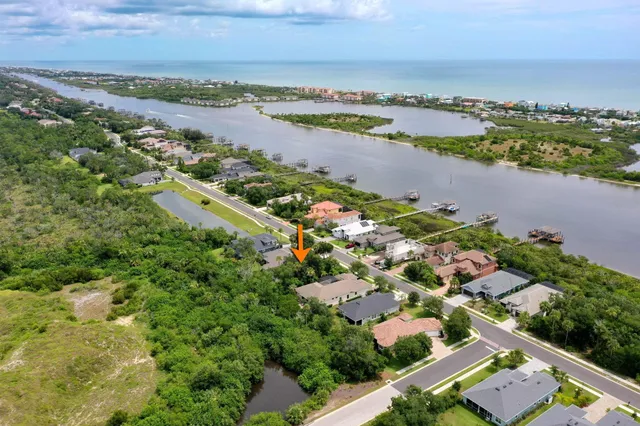 an aerial view of ocean and residential houses with outdoor space