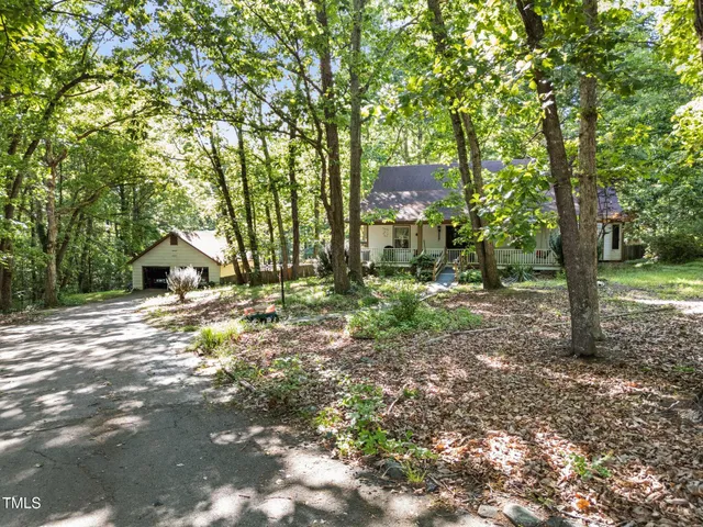a backyard of a house with lots of green space and fountain