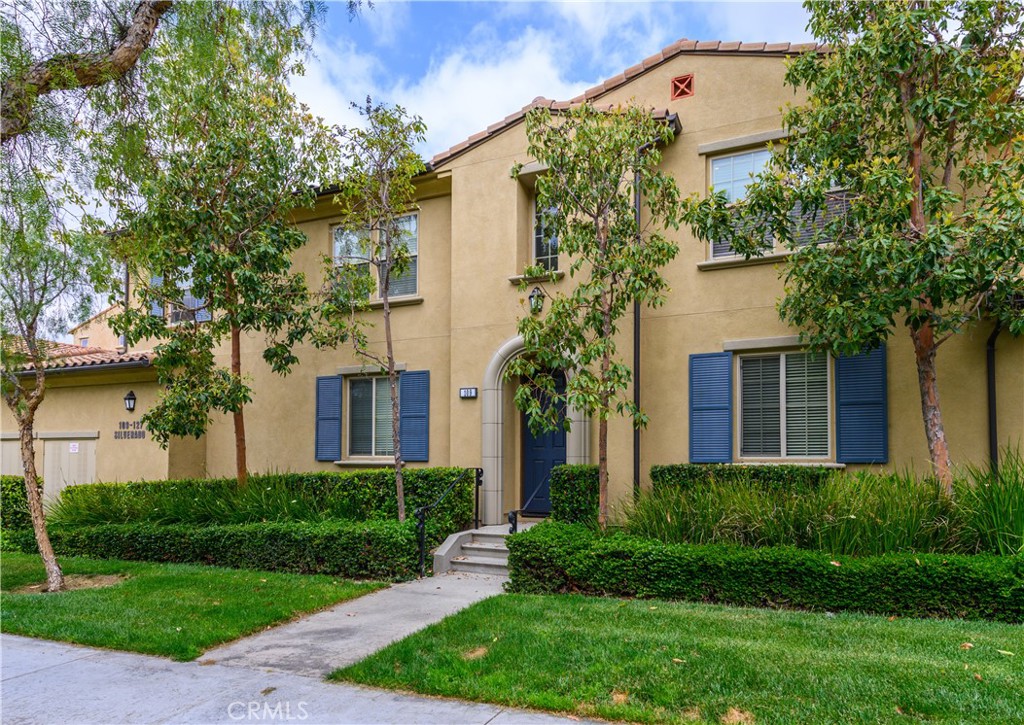 a front view of a house with a yard and trees