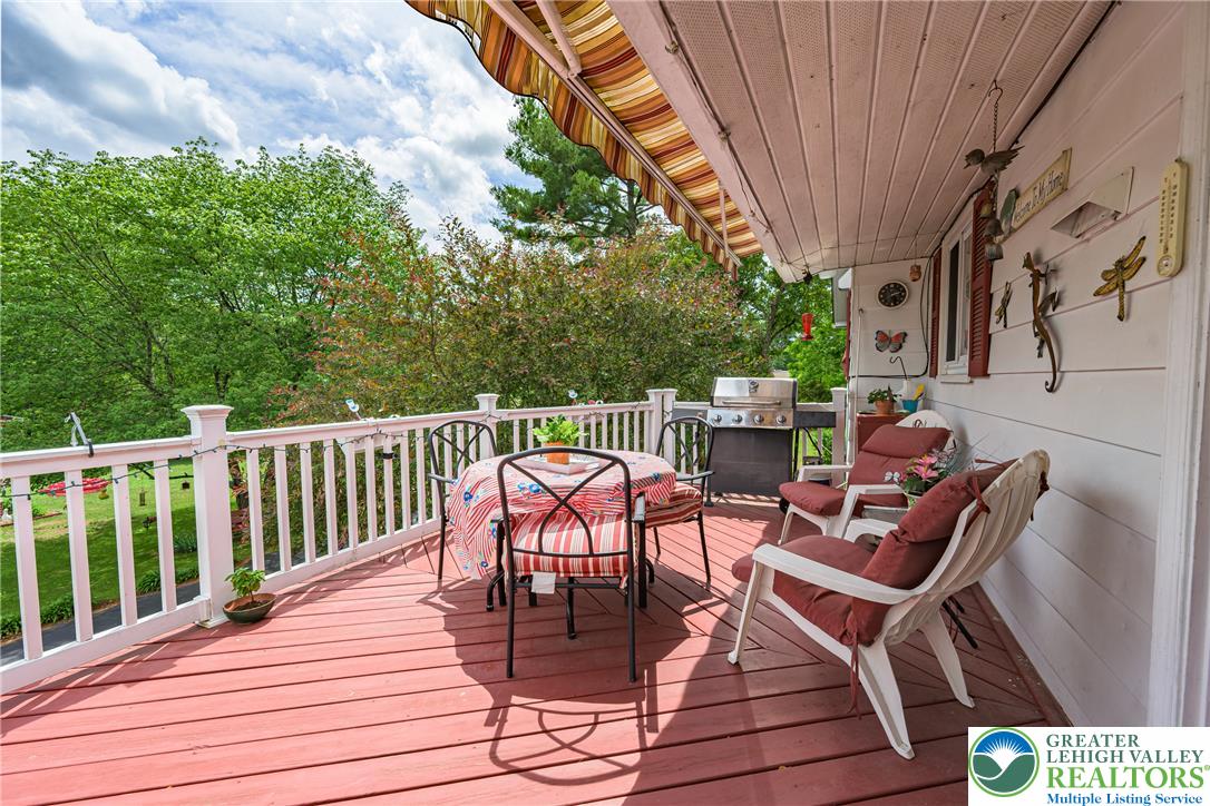 678 Interchange Road Kresgeville, PA 18333 - Photo 13 of 45 A cheerful awning shades this welcoming deck, ideal for outdoor entertaining amidst verdant scenery.