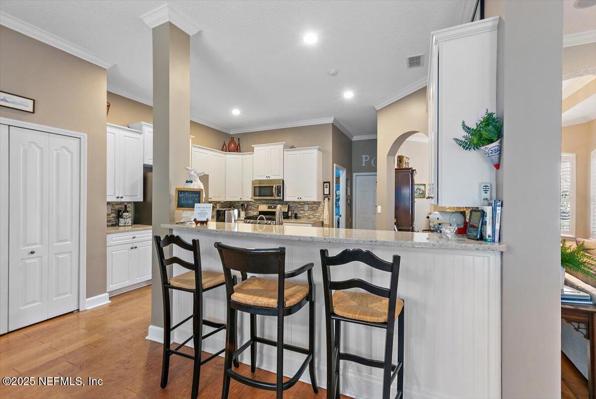 1400 Barrington Circle St. Augustine, FL 32092 - Photo 8 of 45 a kitchen with stainless steel appliances kitchen island granite countertop a table and chairs in it