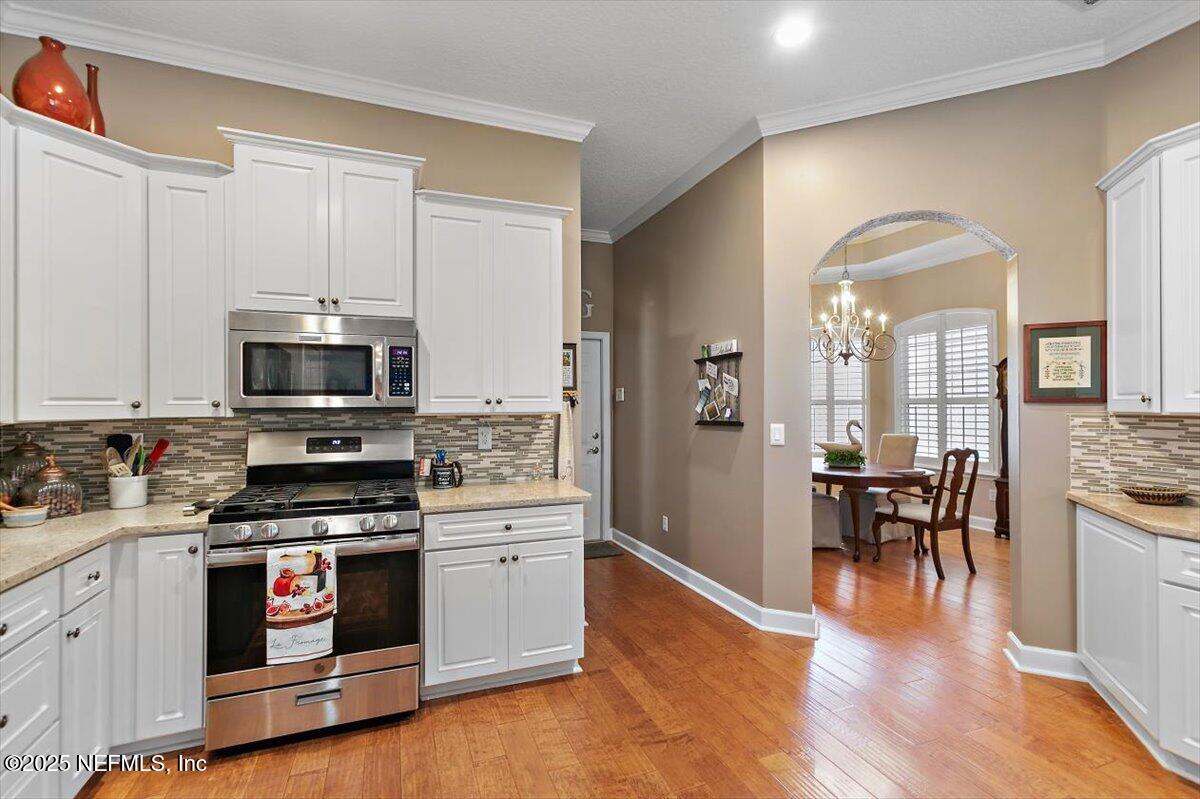 1400 Barrington Circle St. Augustine, FL 32092 - Photo 9 of 45 a kitchen with stainless steel appliances a stove and wooden floor