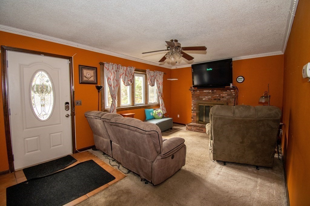 33 Leno Road Holland, MA 01521 - Photo 6 of 32 a living room with furniture a ceiling fan a flat screen tv and a window