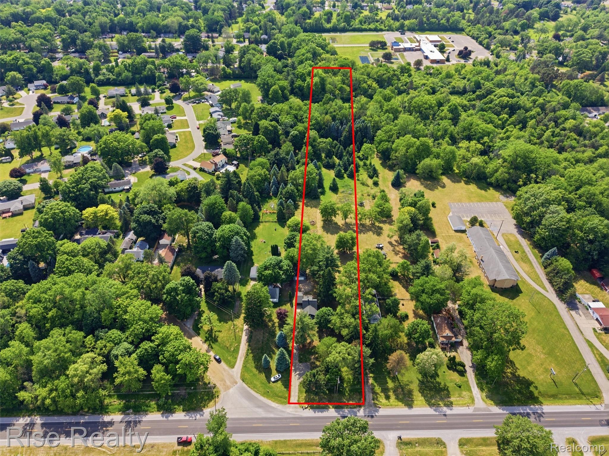 2449 North Genesee Road Burton, MI 48509 - Photo 34 of 40 Expansive land parcel featuring mature trees, a long rectangular shape, and direct road frontage
