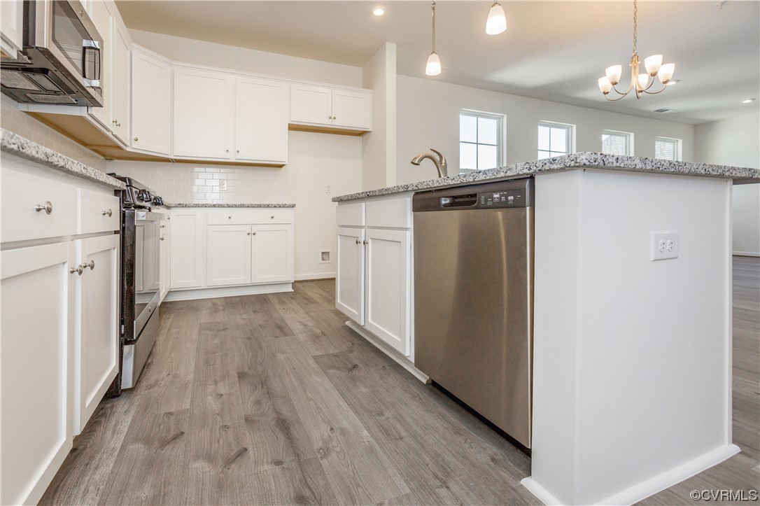 4119 Next Level Trace Midlothian, VA 23112 - Photo 15 of 50 a kitchen with stainless steel appliances granite countertop a refrigerator a sink dishwasher a stove and white countertops with wooden floor