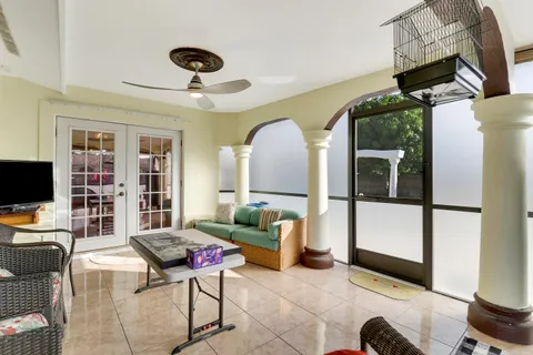 a living room with furniture a flat screen tv and a floor to ceiling window