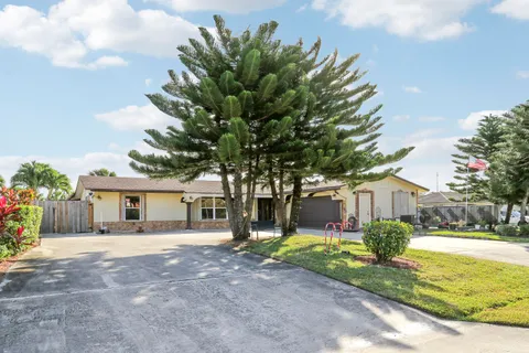 a front view of a house with a yard and potted plants