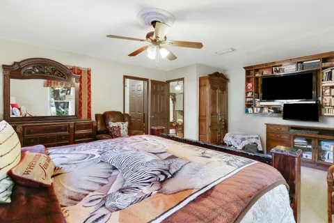 a bedroom with a bed a flat screen tv and dresser