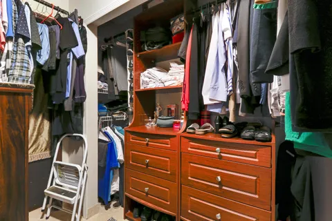 a view of walk in closet with clothes and shoes