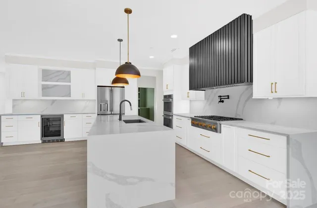 a kitchen with stainless steel appliances granite countertop a stove a sink and a microwave