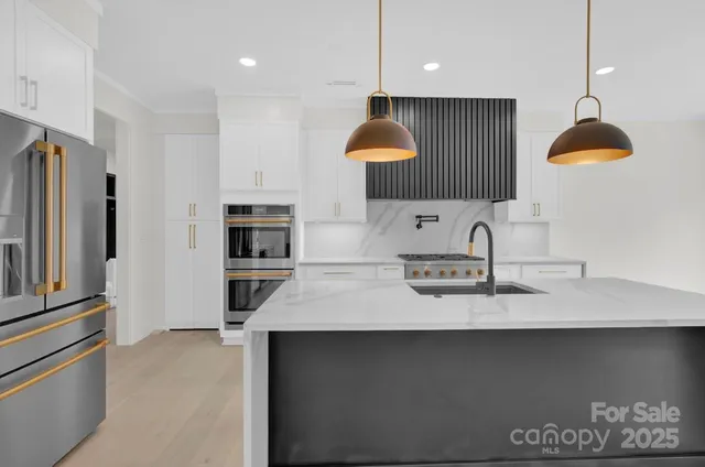 a kitchen with kitchen island a sink stainless steel appliances and cabinets
