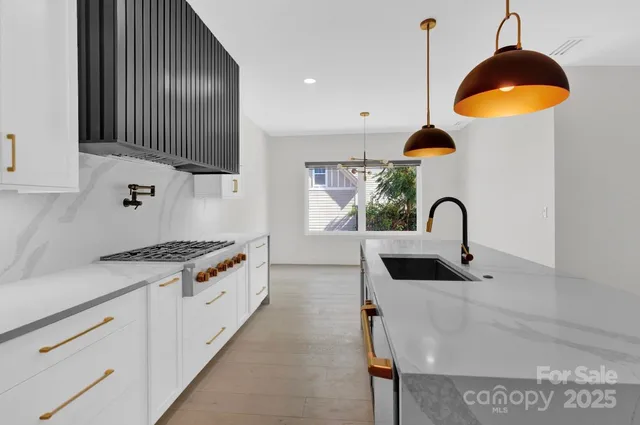 a kitchen with stainless steel appliances granite countertop a stove a sink and a microwave