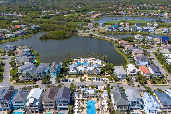 an aerial view of ocean and residential houses with outdoor space