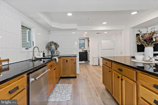 a large kitchen with stainless steel appliances lots of counter space and wooden floor