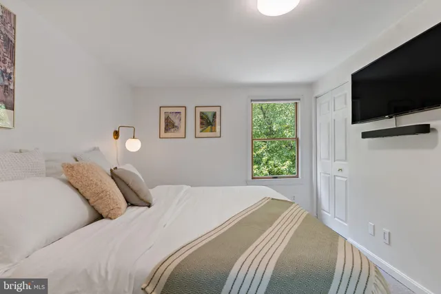 a bedroom with a bed and a flat screen tv