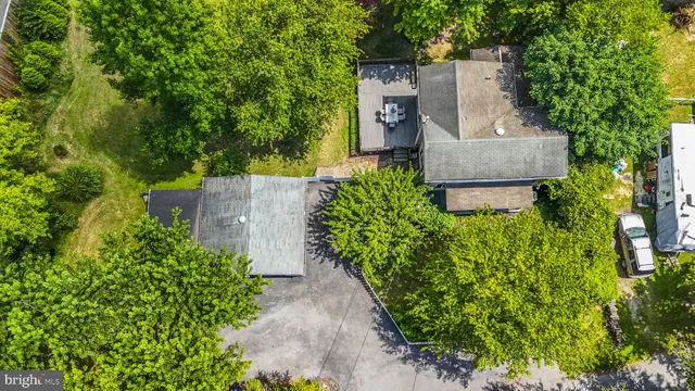 an aerial view of a house with a yard and large trees