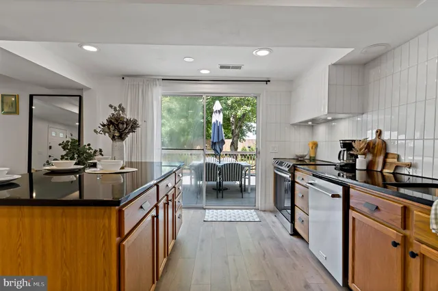a kitchen with stainless steel appliances granite countertop sink stove and refrigerator