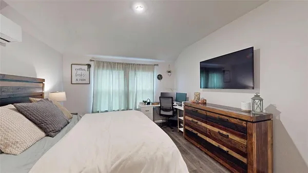 a bedroom with a bed and a flat screen tv