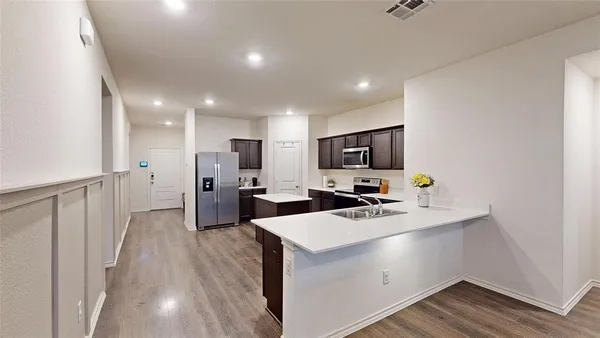 a kitchen with a sink a counter top space stainless steel appliances and cabinets