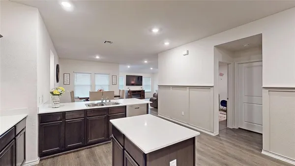 a kitchen with a sink a refrigerator and cabinets
