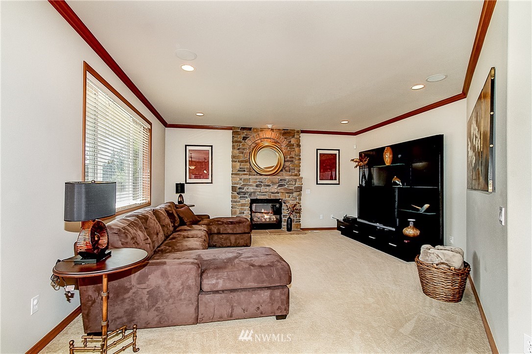 4004 215th Street Southeast Bothell, WA 98021 - Photo 11 of 25 a living room with furniture a flat screen tv and a fireplace