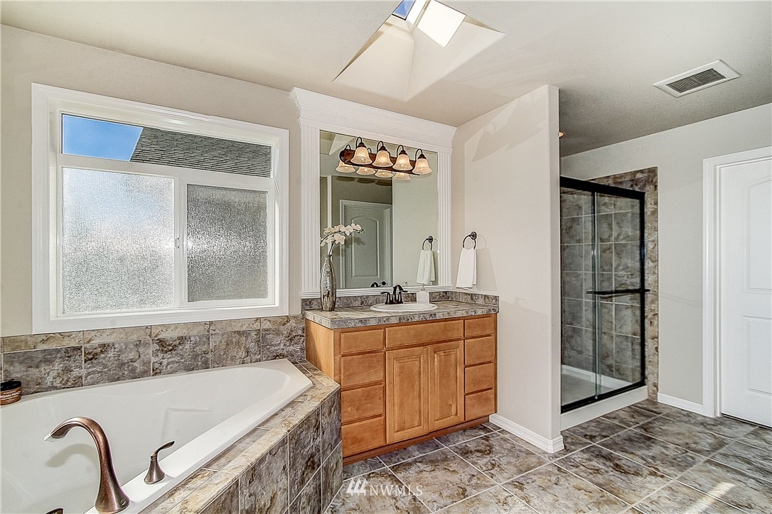 4004 215th Street Southeast Bothell, WA 98021 - Photo 16 of 25 a bathroom with a tub sink and mirror