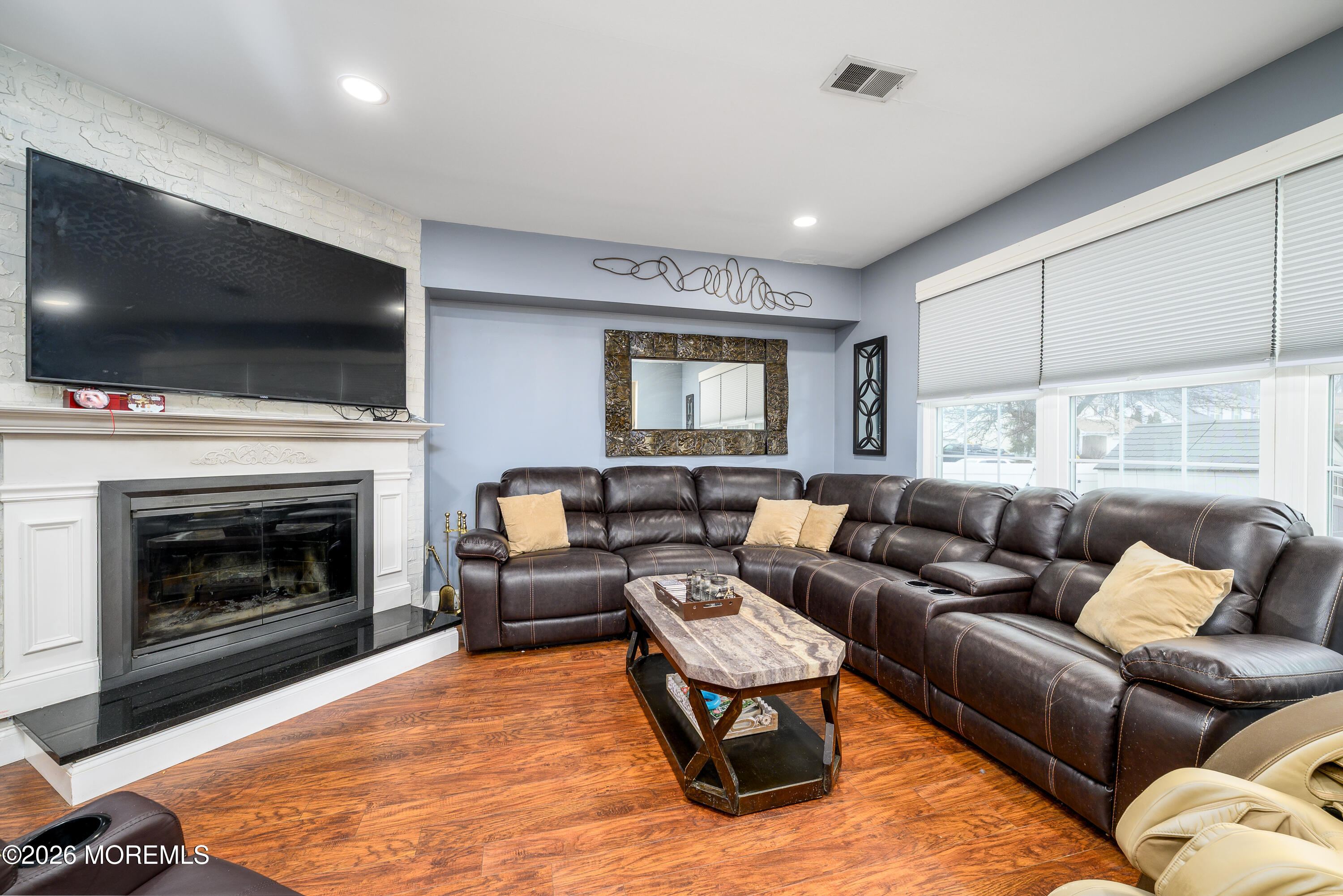 4 Cambridge Drive Howell, NJ 07731 - Photo 17 of 39 a living room with furniture a flat screen tv and a fireplace