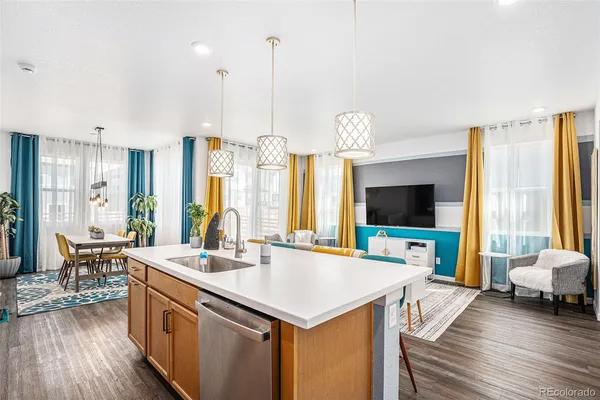 a view of living room with kitchen island granite countertop furniture and a flat screen tv