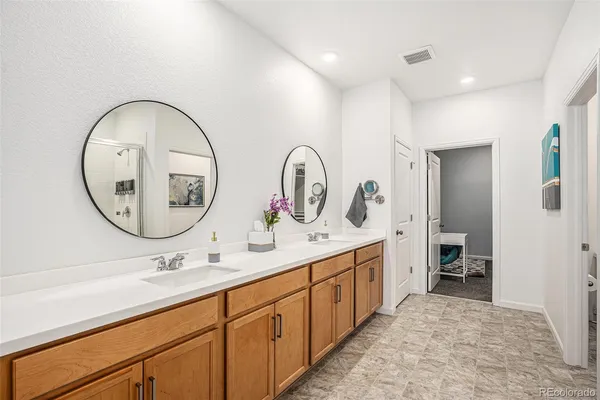 a spacious bathroom with a double vanity sink and a mirror
