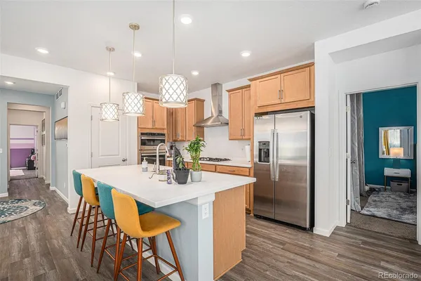 a kitchen with kitchen island a refrigerator and a dining table