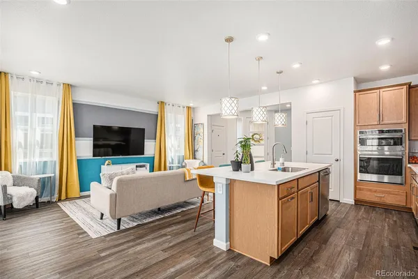 a view of kitchen with stainless steel appliances granite countertop a stove and a wooden floors