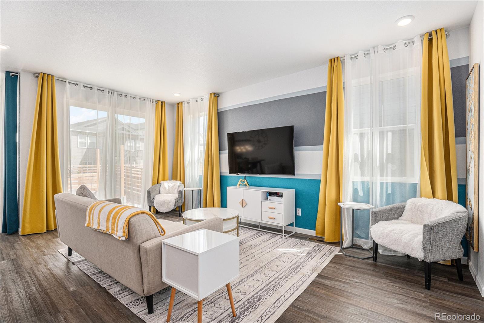 3522 North Buchanan Way Aurora, CO 80019 - Photo 9 of 30 a living room with furniture and a flat screen tv