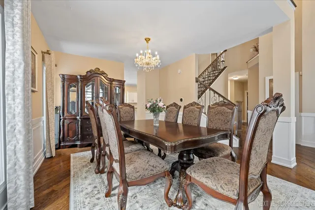 a dining room with stainless steel appliances kitchen island granite countertop a dining table chairs and a refrigerator