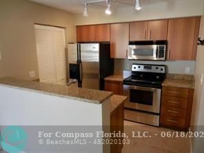 1020 Crystal Way, Unit D Delray Beach, FL 33444 - Photo 19 of 24 a kitchen with granite countertop a refrigerator and a stove