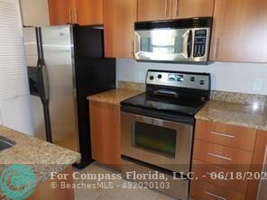 1020 Crystal Way, Unit D Delray Beach, FL 33444 - Photo 10 of 24 a kitchen with granite countertop cabinets and steel stainless steel appliances