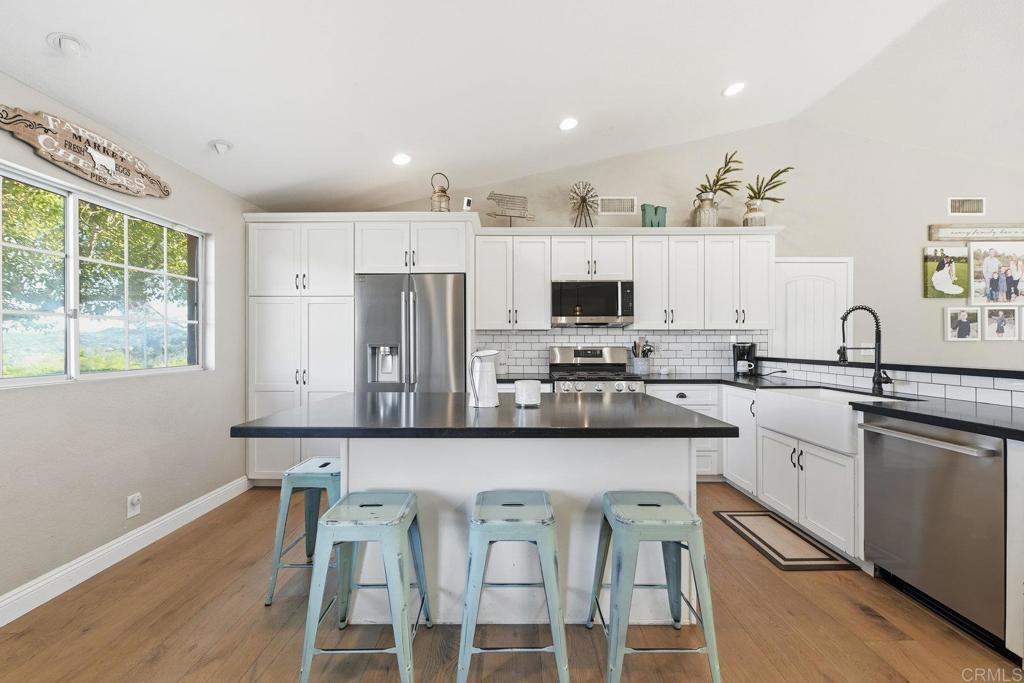 13638 West Oak Glen Road Valley Center, CA 92082 - Photo 14 of 30 a kitchen with stainless steel appliances kitchen island granite countertop a stove and white cabinets